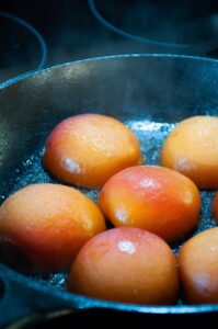 halved apricots face down in skillet with butter