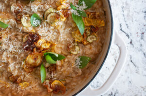 close up of risotto in casserole dish garnished with leafy greens